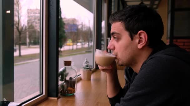 Een Jongeman Die Koffie Drinkt Het Café Door Het Raam — Stockvideo