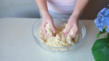 Kız elleriyle hamuru yoğuruyor. Ev yapımı kurabiyeler. Malzemeler ve hazırlık aşamaları. Aşçılık ve pastacılık adımları.
