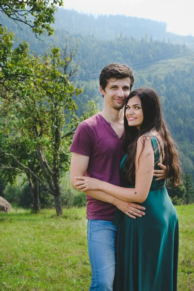 山の上でエレガントで美しいカップル 女の子でザ長いです緑のドレスとともにボーイフレンド — ストック写真
