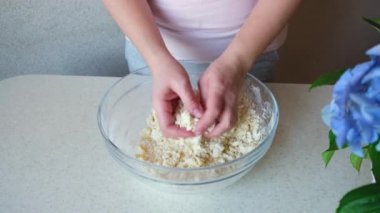 Kız elleriyle hamuru yoğuruyor. Ev yapımı kurabiyeler. Malzemeler ve hazırlık aşamaları. Aşçılık ve pastacılık adımları.