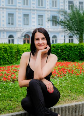 Güzel, esmer bir kadın parkın dışında dinleniyor. Gülümse, Batumi, Georgia 'daki tatlı kız. Yaz zamanı..