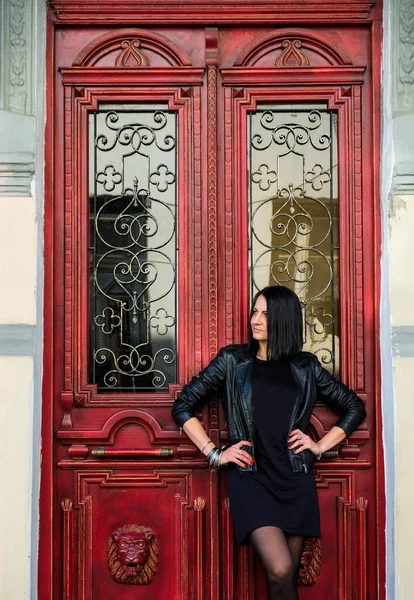 Брюнетка Черной Кожаной Куртке Стоит Старой Красной Двери Рок Концепция — стоковое фото