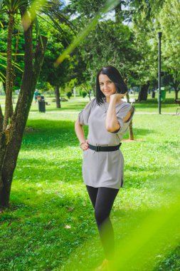 Şehir parkında palmiyelerle yürüyen güzel esmer kadın. Gülümse, Batumi, Georgia 'daki tatlı kız. Yaz zamanı..