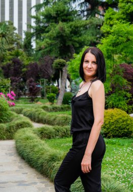 Güzel, esmer bir kadın parkta dinleniyor, yürüyor. Gülümse, Batumi, Georgia 'daki tatlı kız. Yaz zamanı..