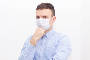 Portrait of a man on a white isolated background, face covered with a medical mask, banner for text. Health, awareness, and timeliness. Healthy lifestyle. No viruses. clipart