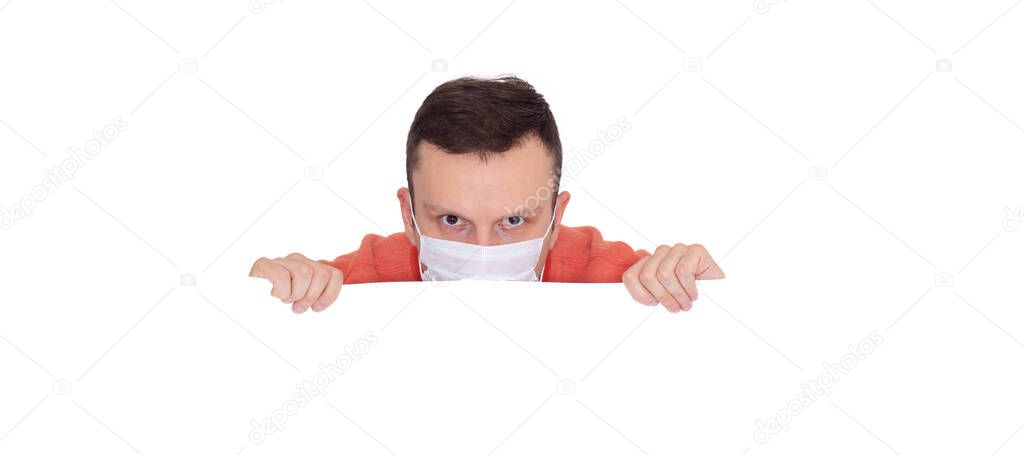 Portrait of a man on a white isolated background, face covered with a medical mask, banner for text. Health, awareness, and timeliness. Healthy lifestyle. No viruses.