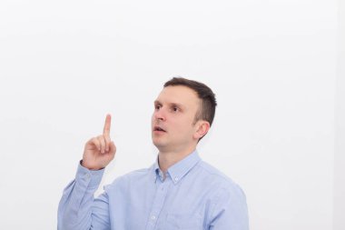 Mesajınız burada. Güzel bir adam beyaz bir arka plana ve mesaj atılacak bir yere işaret eder. Pembe arkaplanlı Renkli Stüdyo portresi.