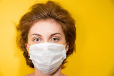 Close-up Portrait of a young woman in a medical mask protecting against the coronavirus pandemic, face protection against the spread of the covid-19 virus, epidemic concept clipart