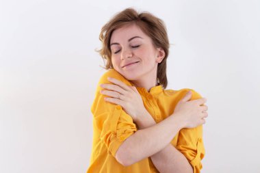 Hoş görünümlü, sevimli, çekici, çekici, etkileyici, bakımlı, hoş, sakin, barışçıl, neşeli kızın portresi beyaz pastel arka planda kendini soyutluyor.