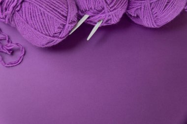 Örgü aletleri ve aksesuarları olan arka plan, renkli mor kepek ipliği, hobi konsepti, kopyalanma alanı