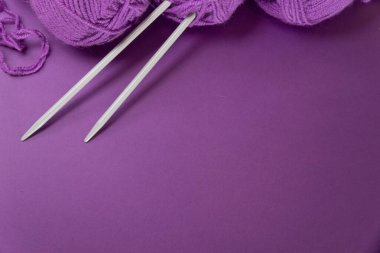 Örgü aletleri ve aksesuarları olan arka plan, renkli mor kepek ipliği, hobi konsepti, kopyalanma alanı