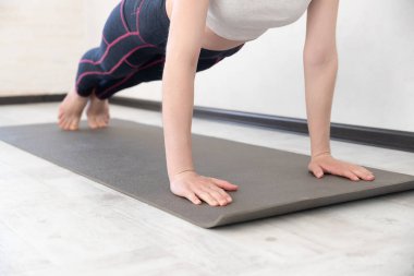 Sukhasana 'da yoga dersi alan genç bir kadın, kolay koltuk pozu, Mudra jesti, egzersiz, bileklik takan kadın kolları, kapalı stüdyo.