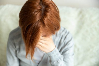 Kanepede oturan çaresiz bir kadının yakın çekimi ve evde üzgün. Duygusal sorunları, korkuları, endişeleri ve umutsuzluğu olan depresif bir milenyum kadını. Psikolojik terapi, enerji eksikliği.