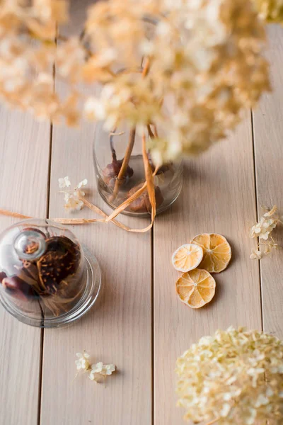 Podzimní zátiší, suché květy hortenzie a citron na dřevěné pozadí — Stock fotografie