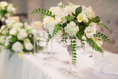 Düğün dekor iç. Masada beyaz çiçekler. Tablo kristal gözlük ile hizmet.