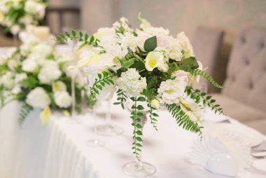 Düğün dekor iç. Masada beyaz çiçekler. Tablo kristal gözlük ile hizmet.