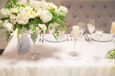 Düğün dekor iç. Masada beyaz çiçekler. Tablo kristal gözlük ile hizmet.