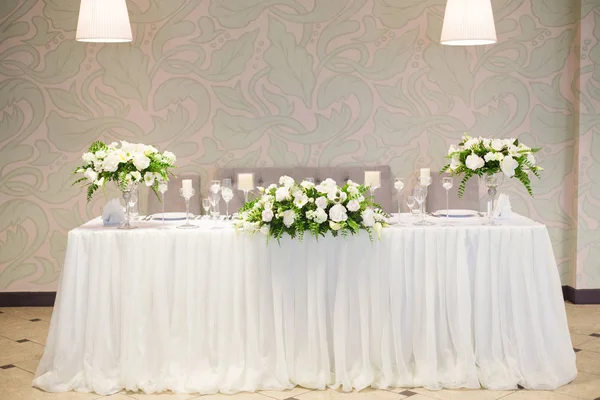 Hochzeitsdekor im Innenraum. weiße Blumen auf dem Tisch. Servieren der Tafel mit Kristallgläsern. — Stockfoto