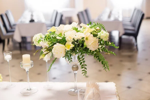 Decoración de la boda en el interior. Flores blancas sobre la mesa. Sirviendo la mesa con vasos de cristal . — Foto de Stock