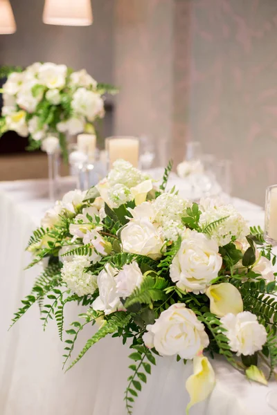 Decoración de la boda en el interior. Flores blancas sobre la mesa. Sirviendo la mesa con vasos de cristal . — Foto de Stock