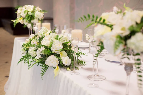 Hochzeitsdekor im Innenraum. weiße Blumen auf dem Tisch. Servieren der Tafel mit Kristallgläsern. — Stockfoto