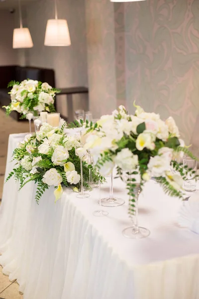 Hochzeitsdekor im Innenraum. weiße Blumen auf dem Tisch. Servieren der Tafel mit Kristallgläsern. — Stockfoto