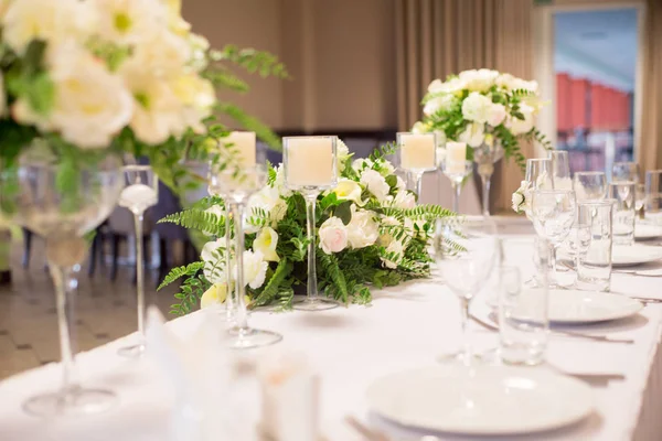 Decoração de casamento no interior. Flores brancas na mesa. Servindo a mesa com óculos de cristal . — Fotografia de Stock