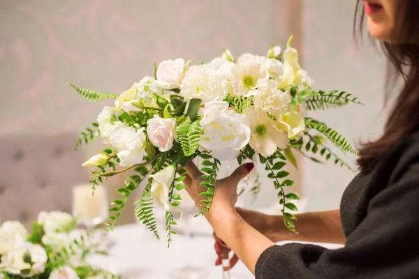 The girl the florist makes a bouquet of flowers. The florist does a bouquet. — Stock Photo, Image