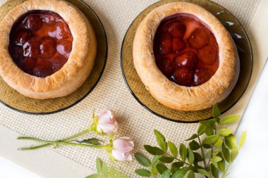 Sabah çayı masaya fırın ürünleri, gül çiçek ile. Çilek pasta. Eski bir peçeteye