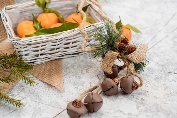 Weihnachten Neujahr Komposition Mandarinen in einem Korb, Tannenzapfen auf einem strukturierten weißen Hintergrund. — Stockfoto
