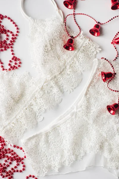 Різдвяна білизна, червоний бісер, гілка зеленої ялинки на білому тлі — стокове фото