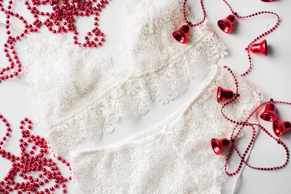 Різдвяна білизна, червоний бісер, гілка зеленої ялинки на білому тлі — стокове фото