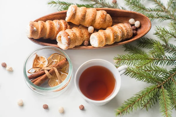Різдвяний чай з випічкою, гілка зеленої ялини, розкидане печиво, равликове печиво з білковим кремом — стокове фото