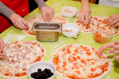 Masada kafede çeşitli malzemelerle pizza hazırlanması