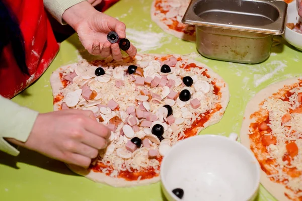 Masada kafede çeşitli malzemelerle pizza hazırlanması