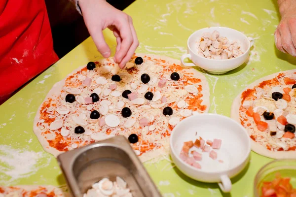 Masada kafede çeşitli malzemelerle pizza hazırlanması