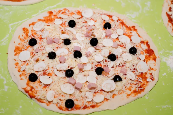 Preparazione di pizza con vari ingredienti nel caffè sul tavolo — Foto Stock