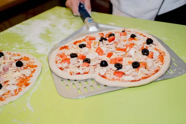 Masada kafede çeşitli malzemelerle pizza hazırlanması