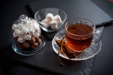 Çeşitli tanımlama bilgilerini ve karanlık rustik masada sıcak baharatlı siyah çay tatlı kış tatil arka plan