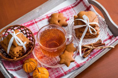 Gingerbread bir tepsi üzerinde sıcak çay ile. Zencefilli bisküvi ahşap bir masa üzerinde büyük bir set