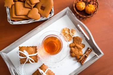 Gingerbread bir tepsi üzerinde sıcak çay ile. Zencefilli bisküvi ahşap bir masa üzerinde büyük bir set