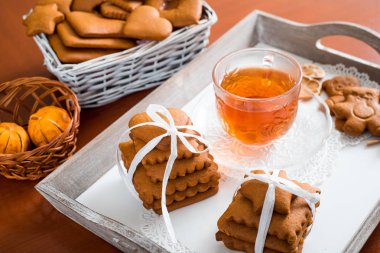 Gingerbread bir tepsi üzerinde sıcak çay ile. Zencefilli bisküvi ahşap bir masa üzerinde büyük bir set