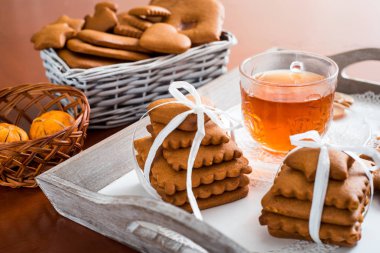 Gingerbread bir tepsi üzerinde sıcak çay ile. Zencefilli bisküvi ahşap bir masa üzerinde büyük bir set