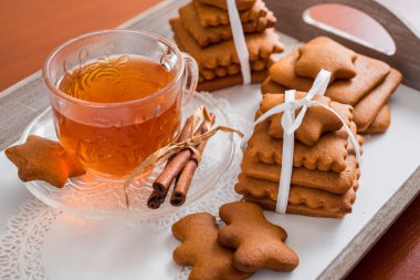 Gingerbread bir tepsi üzerinde sıcak çay ile. Zencefilli bisküvi ahşap bir masa üzerinde büyük bir set