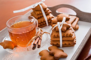 Gingerbread bir tepsi üzerinde sıcak çay ile. Zencefilli bisküvi ahşap bir masa üzerinde büyük bir set