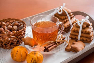 Gingerbread bir tepsi üzerinde sıcak çay ile. Zencefilli bisküvi ahşap bir masa üzerinde büyük bir set
