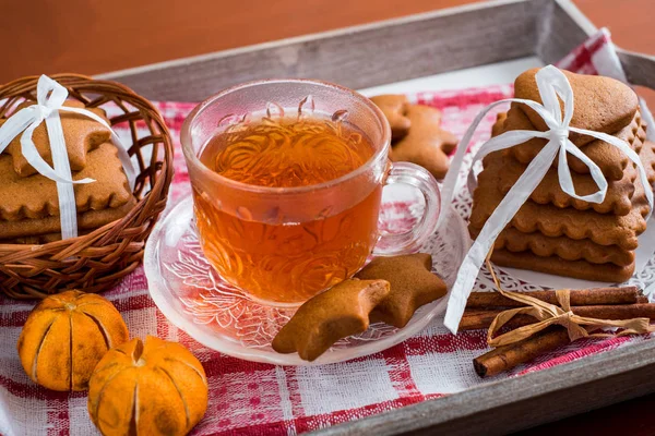 Geleneksel Noel çay, bir bardak sıcak çay, kurabiye ahşap bir masa üzerinde bir tepsi üzerinde büyük bir set ile gingerbread