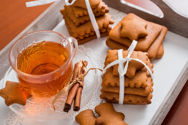 Gingerbread bir tepsi üzerinde sıcak çay ile. Zencefilli bisküvi ahşap bir masa üzerinde büyük bir set