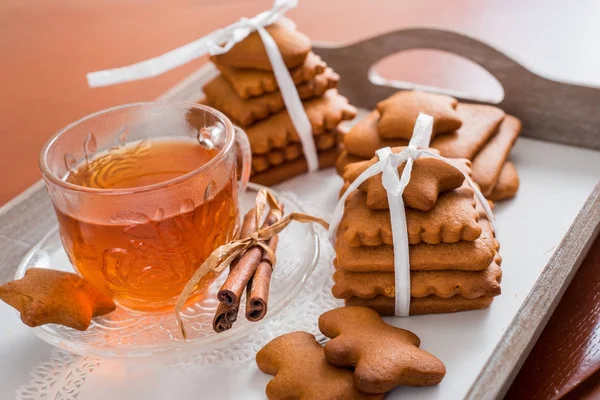 Gingerbread bir tepsi üzerinde sıcak çay ile. Zencefilli bisküvi ahşap bir masa üzerinde büyük bir set