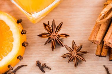 Cam Kavanoz içinde taze portakal suyu. Tarçın, kakule, karanfil baharat. Ahşap bir arka plan üzerinde